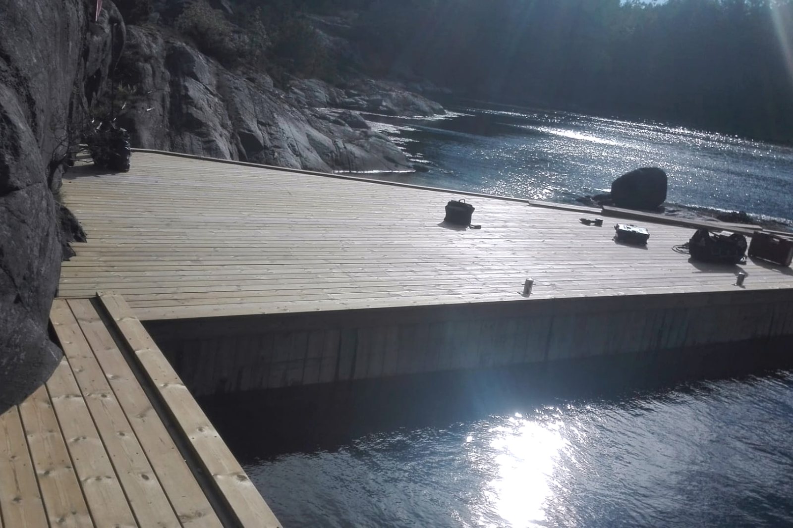 Nylagt trebrygge i motlys ved sjøen