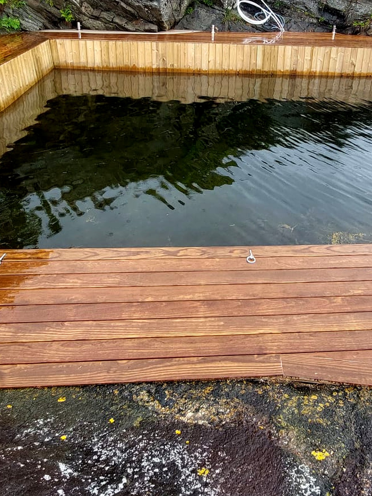 Trebrygge bygget langs svaberg og sjø